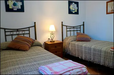 a bedroom with two beds and a lamp on a night stand at Chalet con piscina privada in Conil de la Frontera