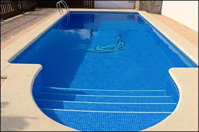 a blue swimming pool with a mermaid painted on it at Chalet con piscina privada in Conil de la Frontera