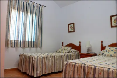 a bedroom with two beds and a window at Chalet con piscina en Roche Viejo in Conil de la Frontera