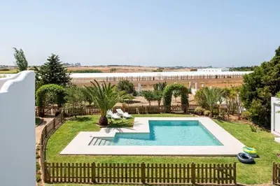 a swimming pool in a yard with a fence at Casa Huerta del Pitorreo in Conil de la Frontera
