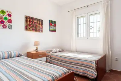 a bedroom with two twin beds and a window at Casa Huerta del Pitorreo in Conil de la Frontera