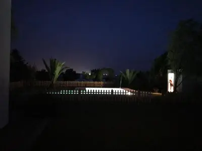 a lit up pool in a yard at night at Casa Huerta del Pitorreo in Conil de la Frontera