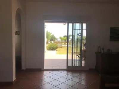 an open door with a view of a yard at Casa Huerta del Pitorreo in Conil de la Frontera