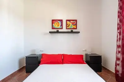 a bedroom with a large bed with red pillows at Casa Huerta del Pitorreo in Conil de la Frontera
