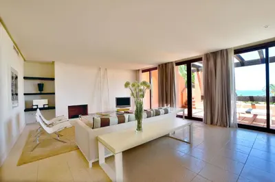 a living room with a white couch and a table at Aparthotel Novo Resort in Chiclana de la Frontera