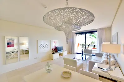 a large white living room with a large chandelier at Aparthotel Novo Resort in Chiclana de la Frontera