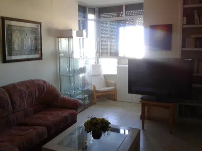 a living room with a couch and a flat screen tv at Precioso piso al lado de la playa in Cádiz