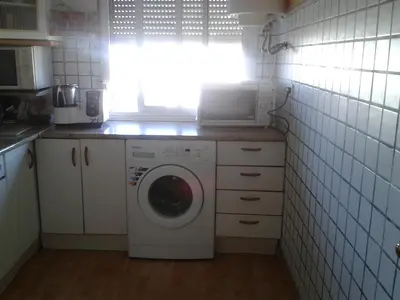 a kitchen with a washing machine and a window at Precioso piso al lado de la playa in Cádiz