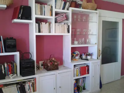 a room with white bookshelves filled with books at Precioso piso al lado de la playa in Cádiz