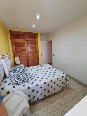 a bedroom with a large bed and a wooden door at Precioso piso al lado de la playa in Cádiz