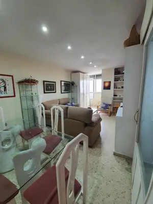 a living room with a couch and a table at Precioso piso al lado de la playa in Cádiz