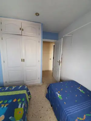 a bedroom with a bed and a closet and a door at Precioso piso al lado de la playa in Cádiz
