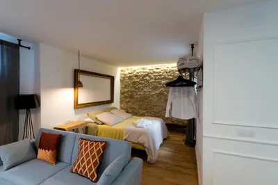 a living room with a bed and a couch at Bohórquez Rooms by Ático73 in Medina Sidonia