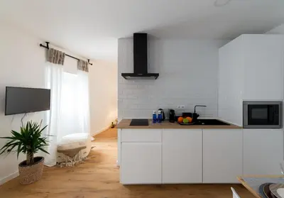 a kitchen with white cabinets and a counter top at Bohórquez Rooms by Ático73 in Medina Sidonia