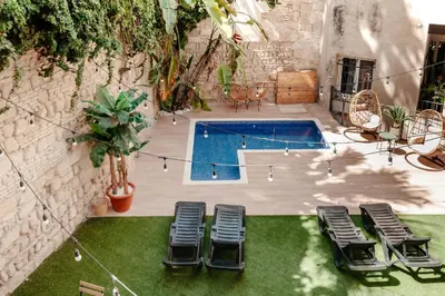 a patio with chairs and tables and a church at ASTUTO Boutique Jerez - Adults Only in Jerez de la Frontera