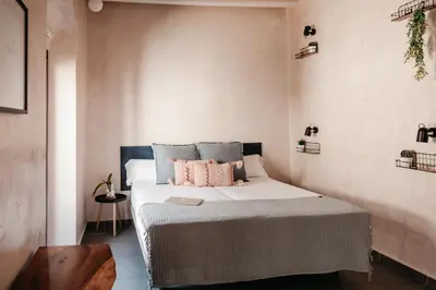 a bedroom with a bed with pink pillows on it at ASTUTO Boutique Jerez - Adults Only in Jerez de la Frontera
