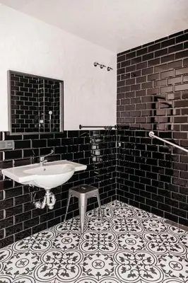 a black and white bathroom with a sink and a stool at ASTUTO Boutique Jerez - Adults Only in Jerez de la Frontera