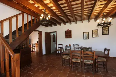 a dining room with a wooden table and chairs at Albara in Conil de la Frontera