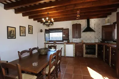 a kitchen with a wooden table and a dining room at Albara in Conil de la Frontera
