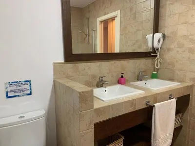 a bathroom with two sinks and a mirror at Villas La Barrosa in Chiclana de la Frontera
