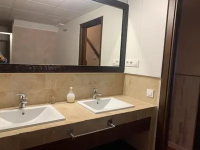 a bathroom with two sinks and a large mirror at Villas La Barrosa in Chiclana de la Frontera
