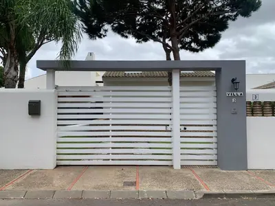 a white garage door with a sign on it at Villas La Barrosa in Chiclana de la Frontera