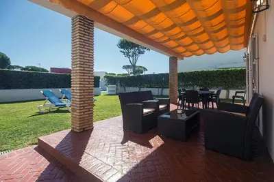a patio with chairs and tables on a brick patio at Villas La Barrosa in Chiclana de la Frontera