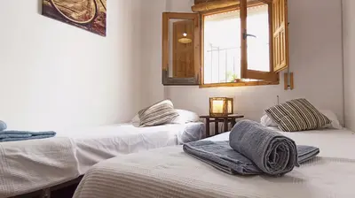 a room with two beds and a window at Apartamento Rústico_Centrico in El Puerto de Santa María