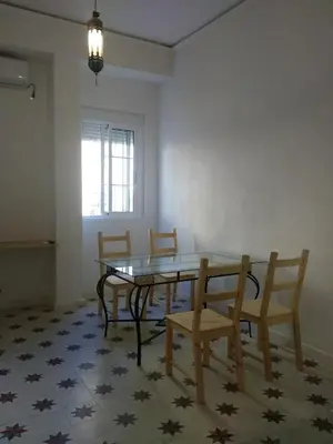 a dining room with a glass table and chairs at Azafran Jerez apartamentos in Jerez de la Frontera
