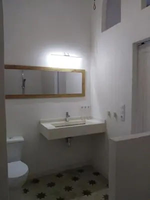 a bathroom with a sink and a toilet and a mirror at Azafran Jerez apartamentos in Jerez de la Frontera