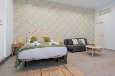 a bedroom with a bed and a couch at Panther Home Aladro III in Jerez de la Frontera