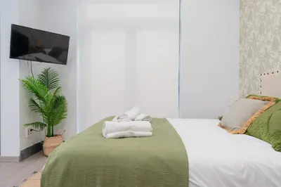 a bedroom with a bed with towels on it at Panther Home Aladro III in Jerez de la Frontera
