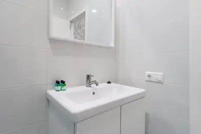 a white bathroom with a sink and a mirror at Panther Home Aladro III in Jerez de la Frontera