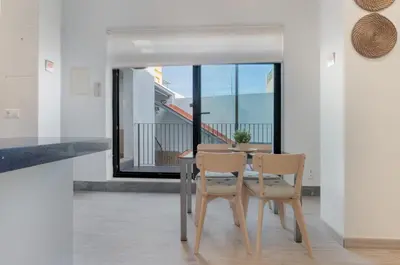 a dining room with a table and chairs and a balcony at Panther Home Aladro III in Jerez de la Frontera