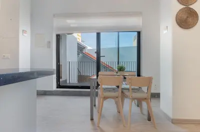 a dining room with a table and chairs and a balcony at Panther Home Aladro III in Jerez de la Frontera