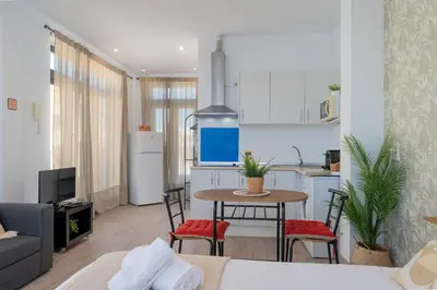 a kitchen and a living room with a table and chairs at Panther Home Aladro V in Jerez de la Frontera