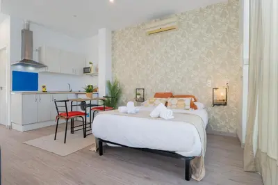 a bedroom with a large bed and a kitchen at Panther Home Aladro V in Jerez de la Frontera