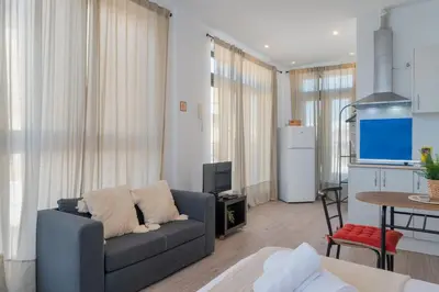 a living room with a couch and a kitchen at Panther Home Aladro V in Jerez de la Frontera