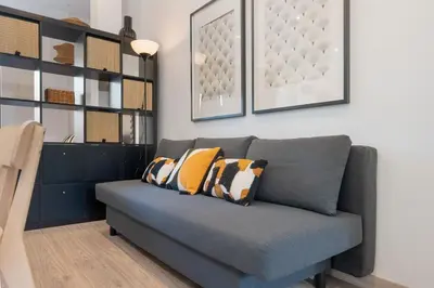 a living room with a gray couch with pillows at Panther Home Aladro IV in Jerez de la Frontera