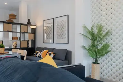 a living room with a couch and a plant at Panther Home Aladro IV in Jerez de la Frontera