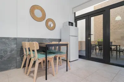 a kitchen with a table and chairs and a refrigerator at Panther Home Aladro in Jerez de la Frontera