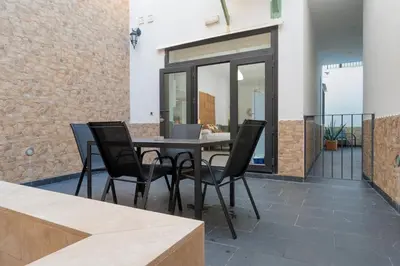 a patio with a black table and chairs at Panther Home Aladro in Jerez de la Frontera