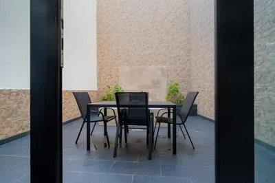 a black dining table and chairs on a patio at Panther Home Aladro in Jerez de la Frontera