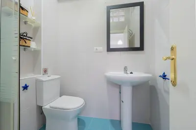 a white bathroom with a toilet and a sink at Panther Home Aladro in Jerez de la Frontera