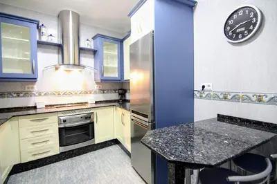 a kitchen with a counter and a clock on the wall at Apartamento SERAFÍN de la Caleta in Cádiz