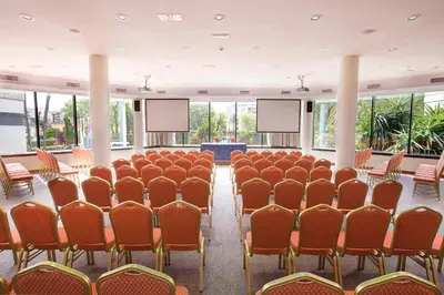 a conference room with rows of chairs and screens at Hipotels Sherry Park in Jerez de la Frontera