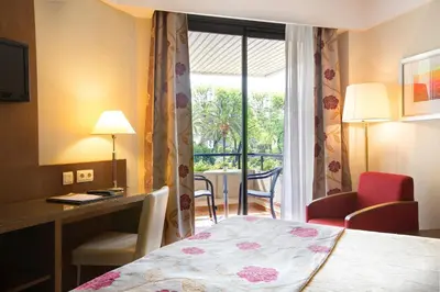 a hotel room with a bed and a desk and a window at Hipotels Sherry Park in Jerez de la Frontera