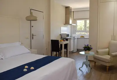 a hotel room with a bed and a kitchen at Aparthotel Novo Sancti Petri in Chiclana de la Frontera