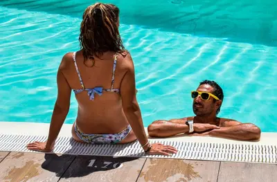 a woman and a man in a swimming pool at Aparthotel Novo Sancti Petri in Chiclana de la Frontera