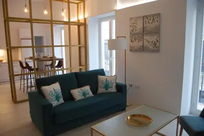 a living room with a blue couch and a table at Guesting Basílica in Jerez de la Frontera